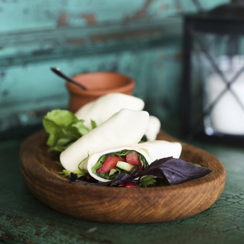 wrap cu diverse ingrediente pe un blat inchis la culoare in castron de lemn