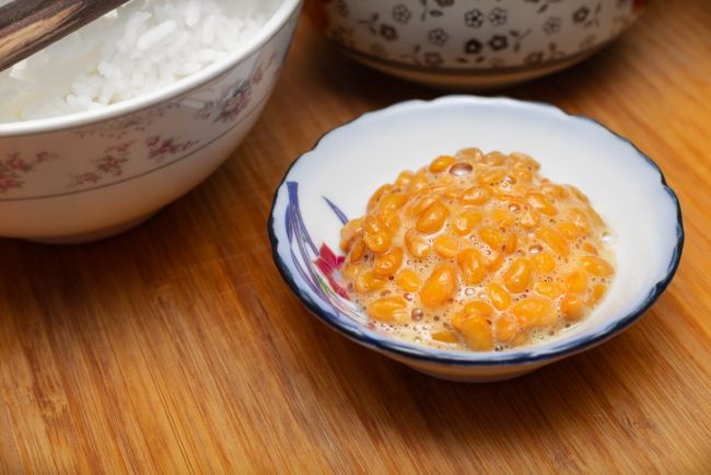 prim plan cu bol de natto pe un suport de lemn
