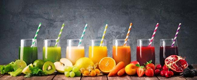 imagine cu sucuri de fructe in diverse culori si fructele din care sunt realizate