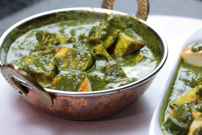 imagine cu bol cu saag paneer in castron de aluminiu pe masa