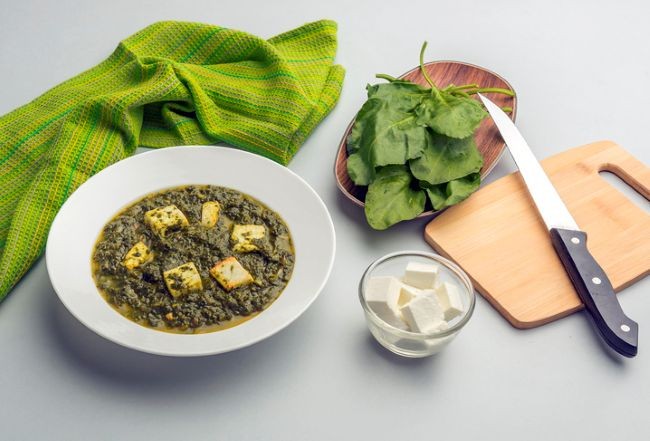 imagine cu portie de saag paneer alaturi de ingrediente , spanac, paneer, blat si cutit