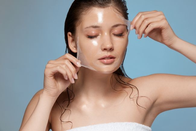 fata care isi trage o pelicula de exfoliere de pe fata
