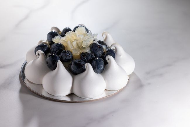 prajitura pavlova cu mure pe un platou de bucatarue