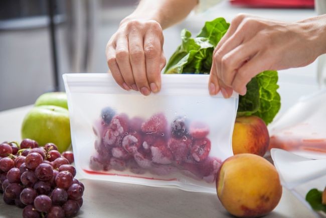 imagine cu persoana care pune legume si fructe in pungi la congelator