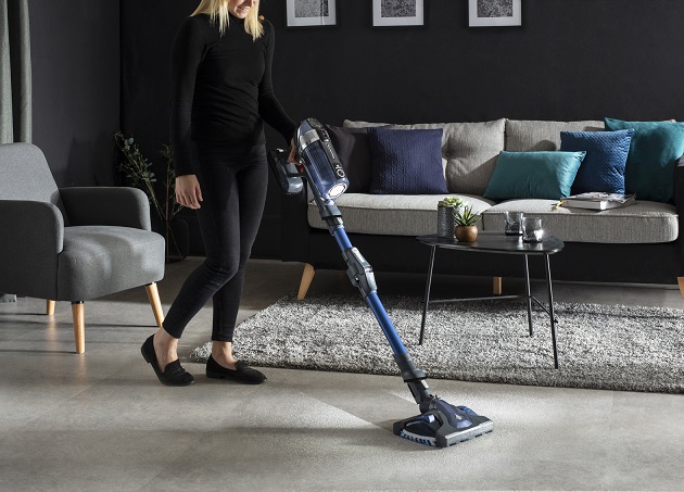 femeie care da cu aspiratorul in casa