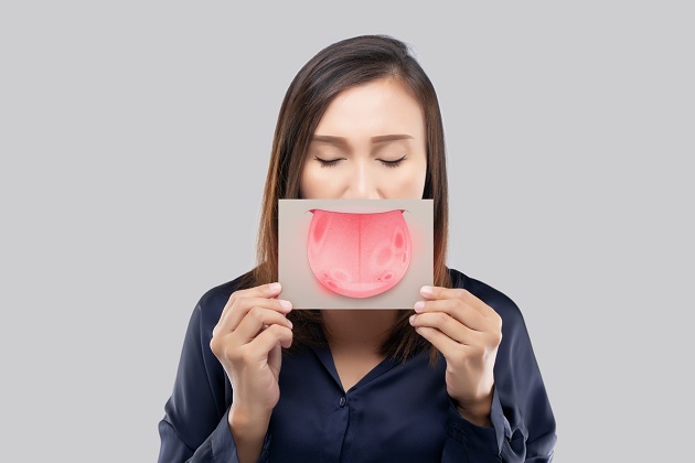 femeie care tine un carton cu o lipba desenata in dreptul gurii