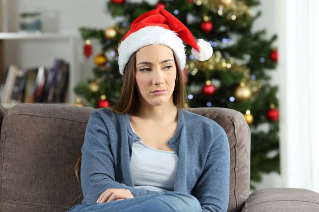 Femeie tristă cu căciulă de Moș Crăciun pe cap