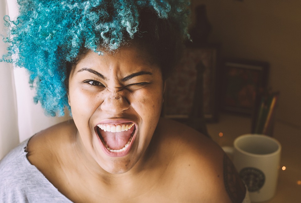 Femeie cu perucă albastră care râde cu putere