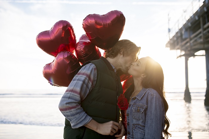 Cuplu de tineri sărutându-se pe un ponton 