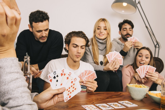 prieteni care se joaca carti la o petrecere in apartament