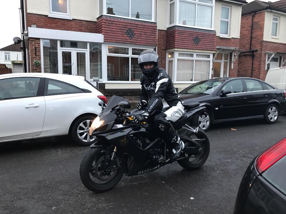 tanar aflat pe motocicleta, pe strada, printre masim