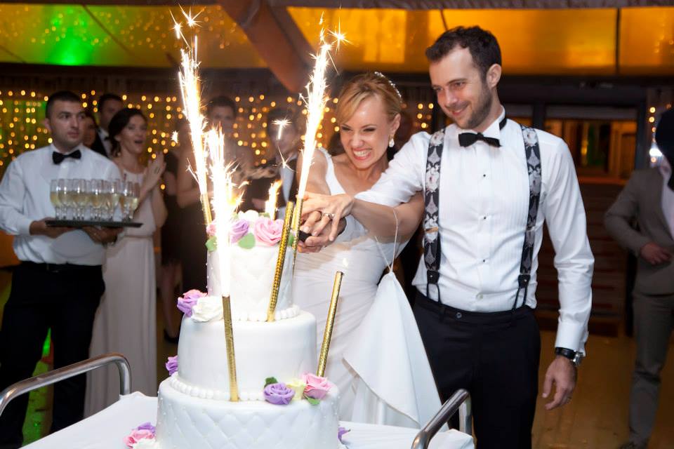 Oana Ioniță și Florin Budnaru tăind tortul la nunta lor 