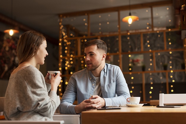 Cuplu care stă de vorbă la o cafenea.