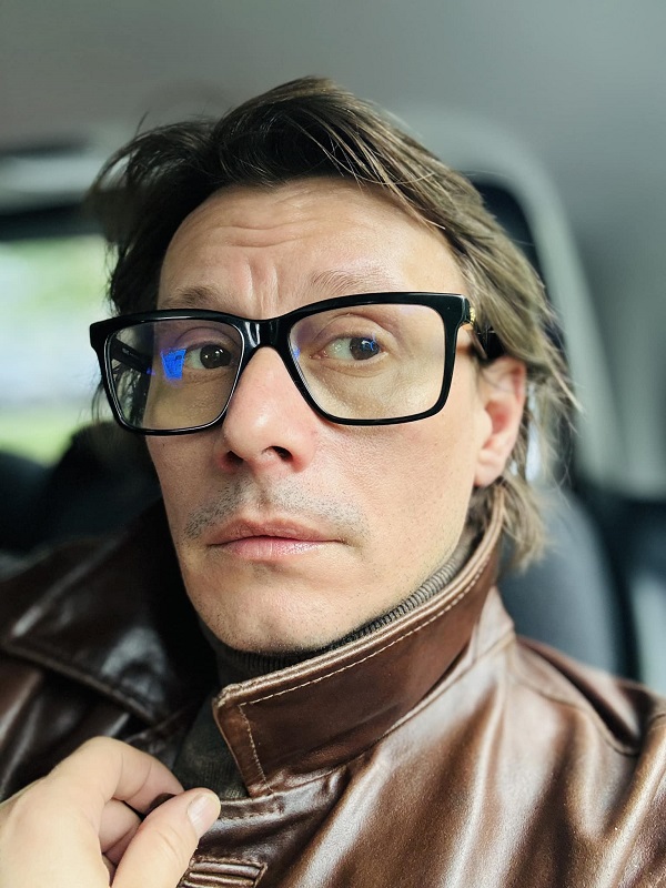 actorul marius manole in masina cu ochelari si geaca de piele