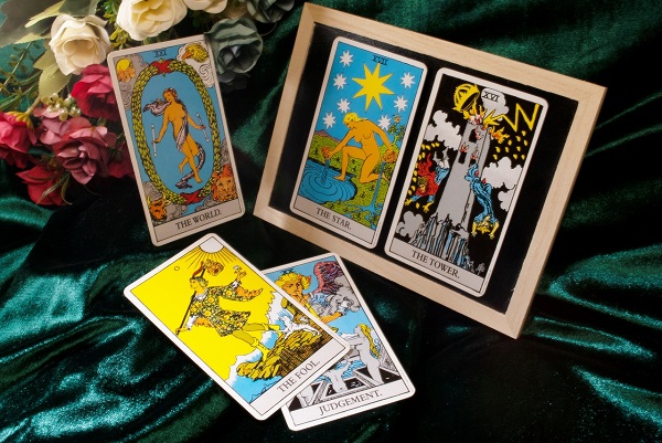 carti de tarot pe o masa acoperita cu catifea verde 