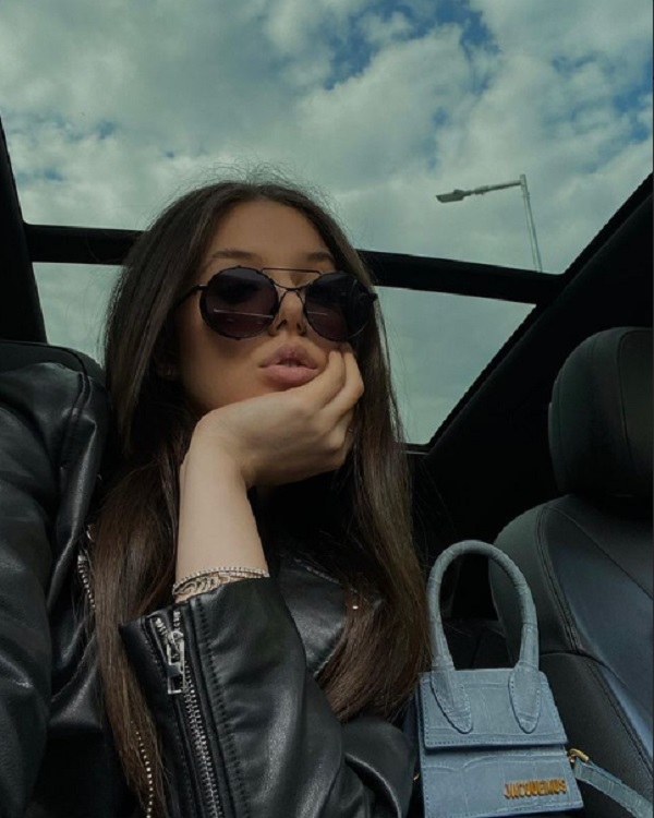 fata lui gica popescu selfie in care isi tine fata in mana  cu geanta si ochelari de soare