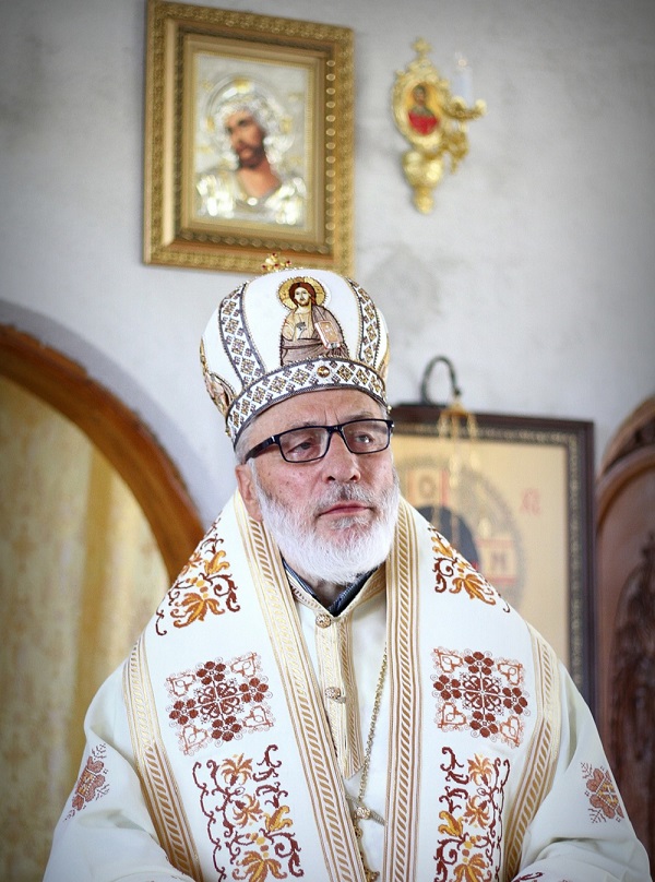 ÎPS muscelului și argesului in timpul unei slujbe imbracat in haine preoțești aurii cu ochelari la ochi