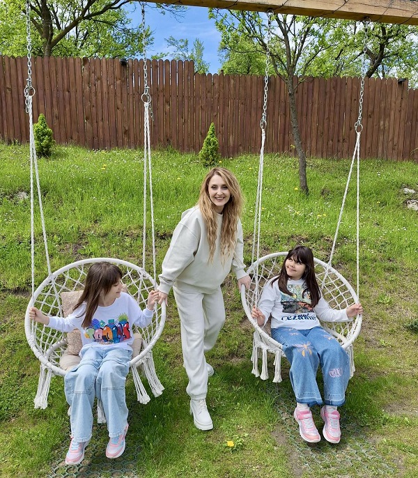 alina sorescu si cele doua fiice ale ei in gradina fetitele se dau in leagane cuib