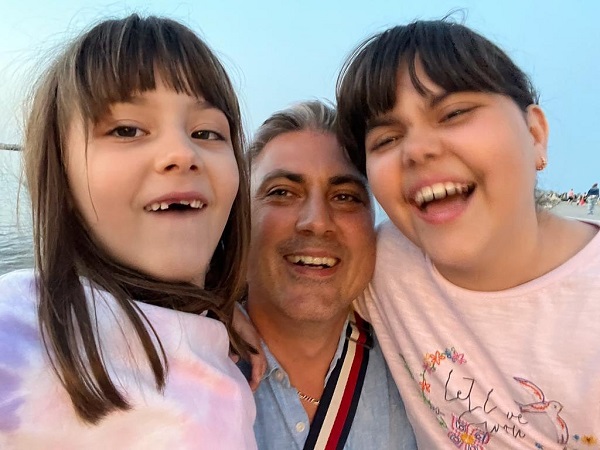 alexandru ciucu impreuna cu fetitele sale imbracate in roz care zambesc pentru selfie