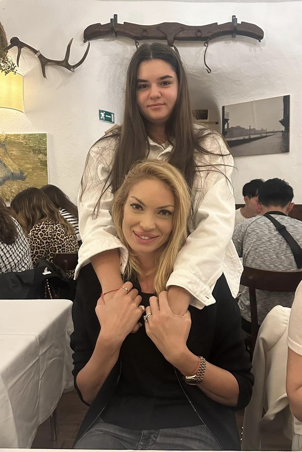 valentina pelinel stand pe scaun imbratisata de fiica lui cristi borcea stand in picioare la o masa la restaurant