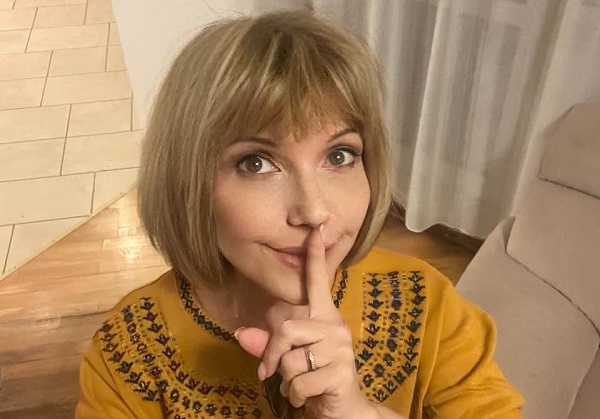 marina almasan imbracata in bluza galbena cu degetul peste buze