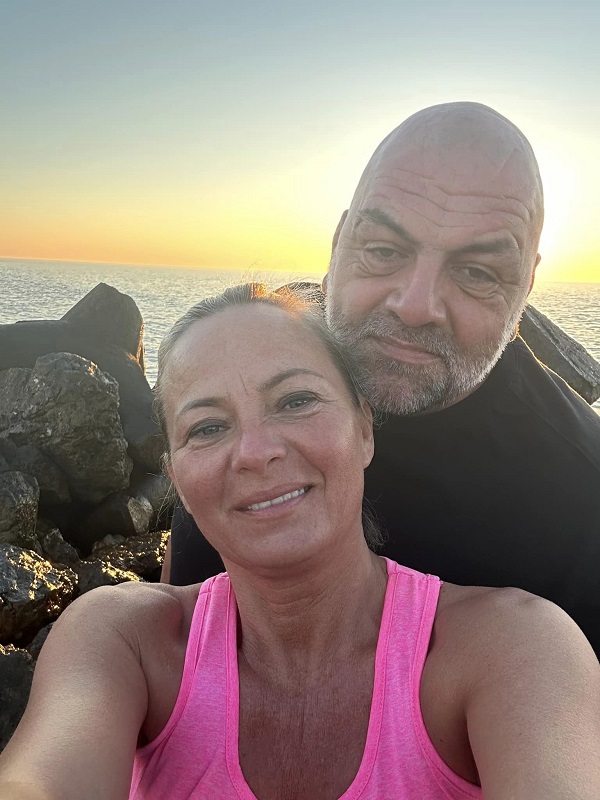 fiul lui costel constantin imbracat in negru si sotia lui imbracata in roz fac un selfie la mare