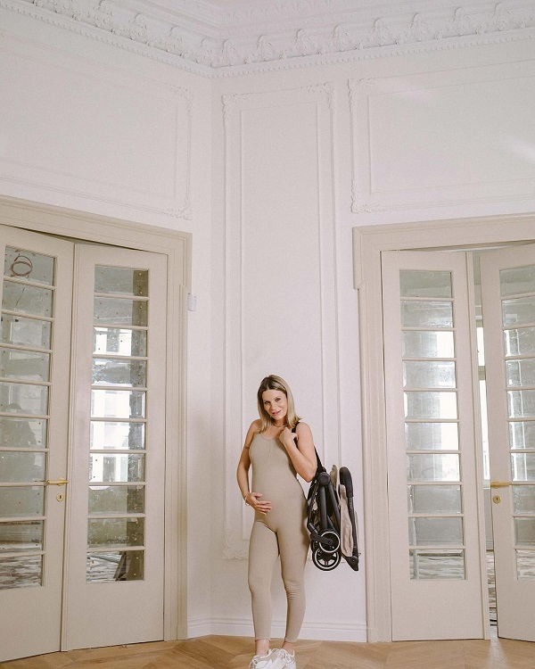 ana baniciu insarcinata in casa purtand un costum nude cu burtica la vedere si un carut pliabil pe umar
