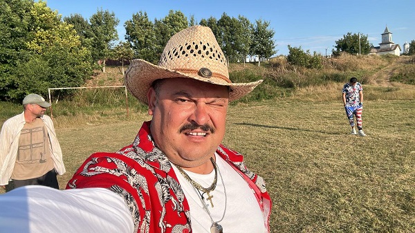 mihai bobonete isi face selfie imbracat in bobita pe un stadion de fotbal in spate actori din las fierbinti