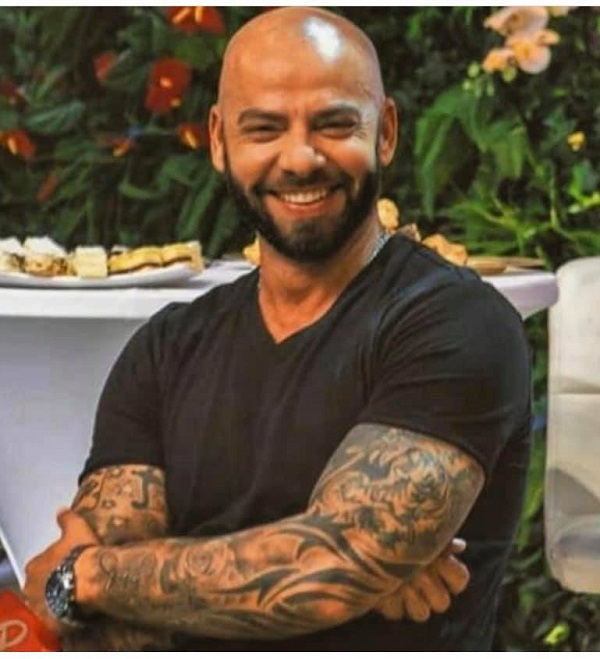 giani kirita cu bratele pline de tatuaje zambeste la camera