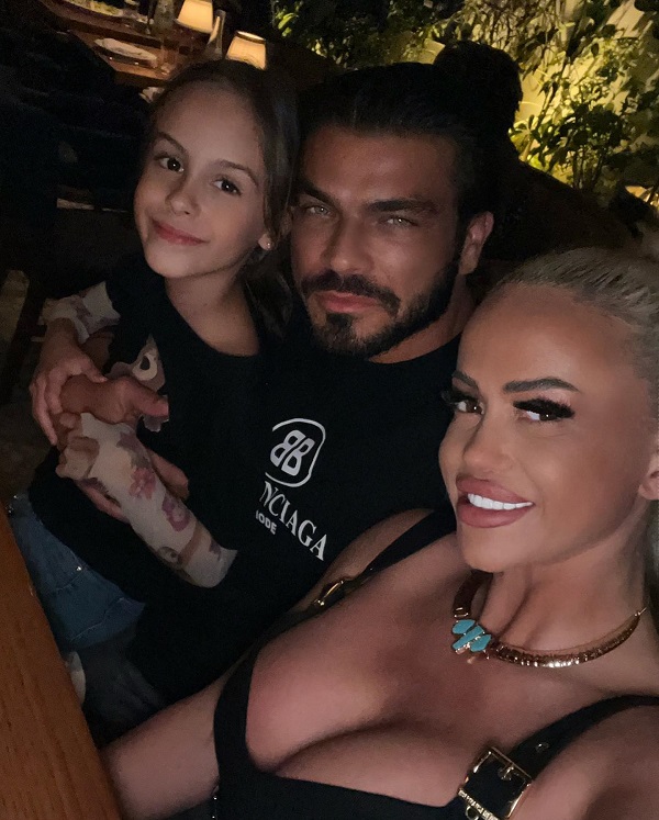 anda adam alaturi de sotul si copilul ei intr-un club in conditii de lumina slaba