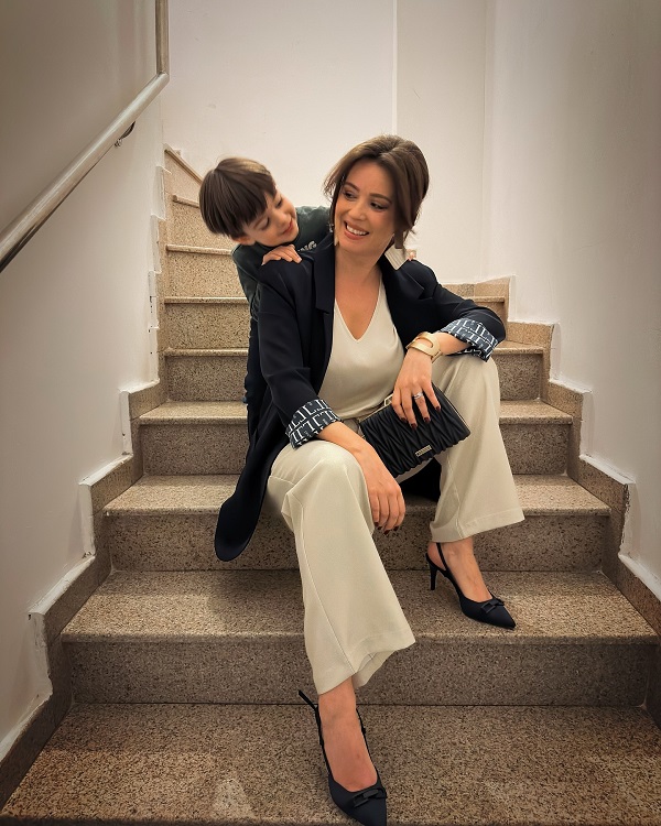 diana dumitrescu imbracata elegant imbratisata de fiul ei pe scarile interioaer