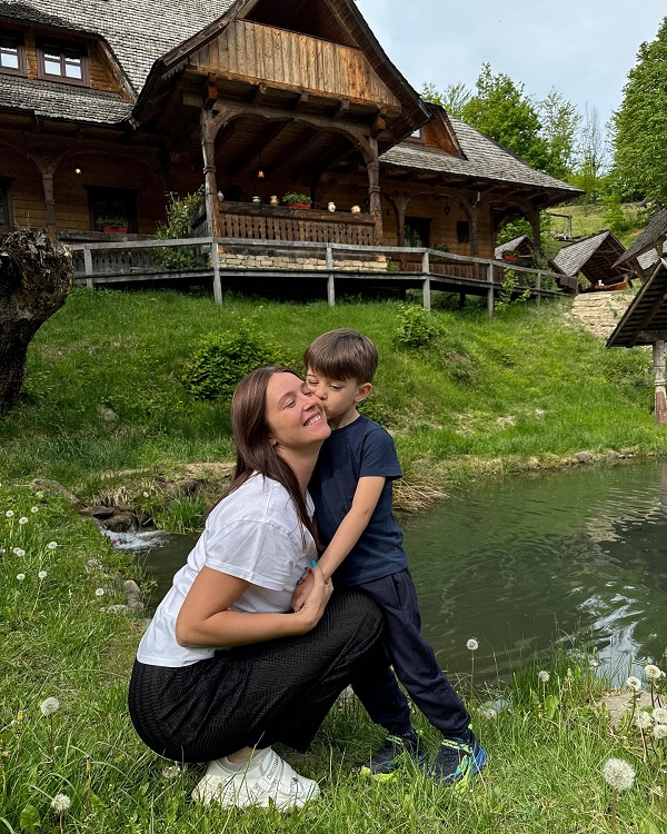 diana dumitrescu pupata pe obraz de fiul ei carol in fata unei pensiuni stand pe iarba