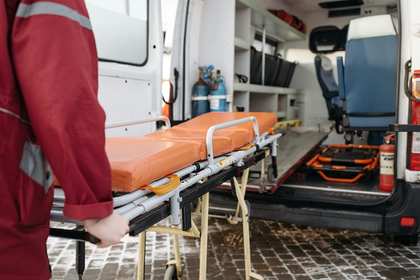 un ambulantier urca o targa in ambulanta