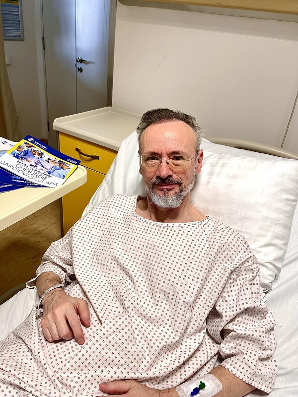 mihai albu in halat alb pe patul de spital dupa operatie