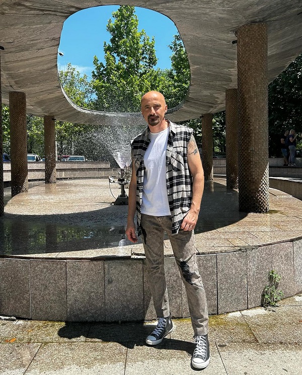 calin goia intr-un parc cu fantana arteziana in spate