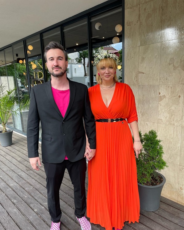 cristina cioran in rochie rosie alaturi de alex dobrescu in costum negru se tin de mana