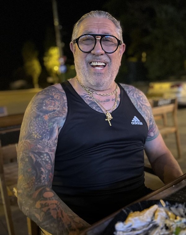 serghei mizil in tricou negru la o masa afara rade