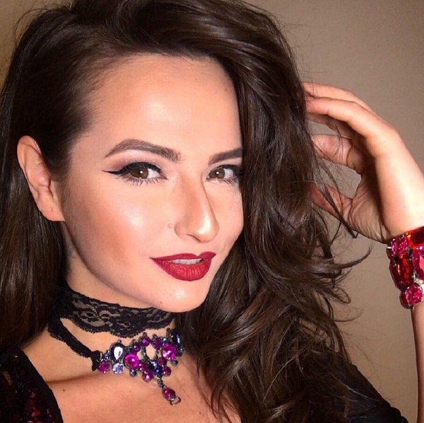 adela lupse machiata aranjata cu parul cu bucle isi trece mana prin podoaba capilara