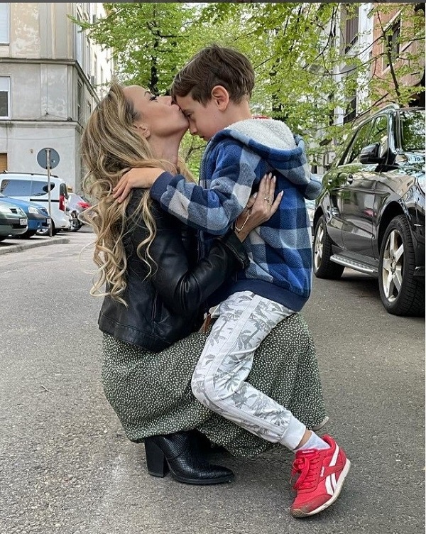 ani cretu in genunchi isi pupa copilul pe frunte pe strada
