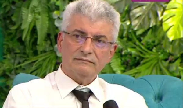 silviu prigoana cu o camasa alba si cravata neagra tine in mana un microfon
