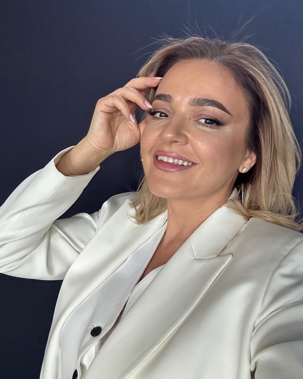 cristina batlan in costum alb isi trece mana prin par