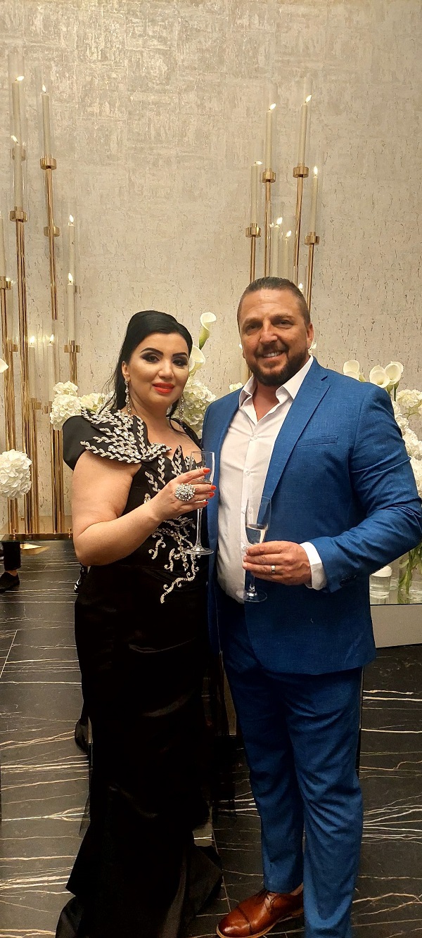 adriana bahmuteanu si logodnicul ei imbracati elegant cu pahare de sampanie in mana