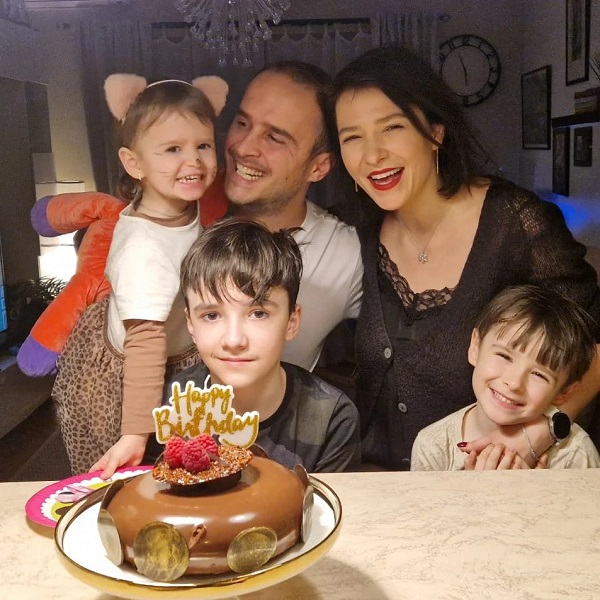 serban copot cu familia si copiii la masa in fata unui tort cu lumanari aprinse