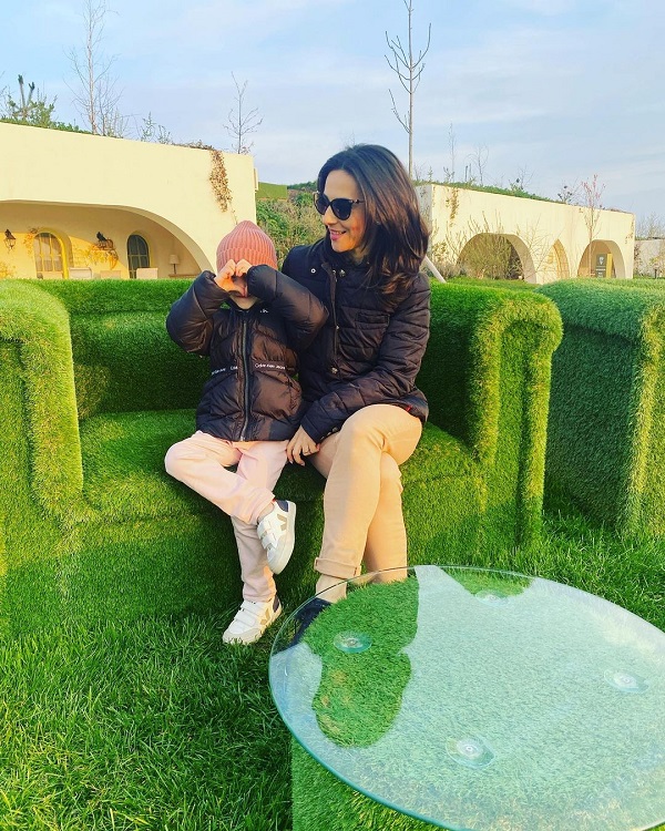 andreea radulescu cu fiica ei pe un fotoliu verde