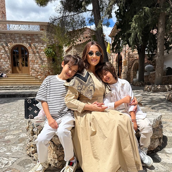 claudia patrascanu imbracata in fusta alba si jacheta alaturi de cei doi copii in natura