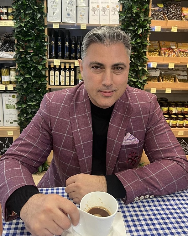 alexandru ciucu intr-o cafenea cu o ceasca de cafea pe masa