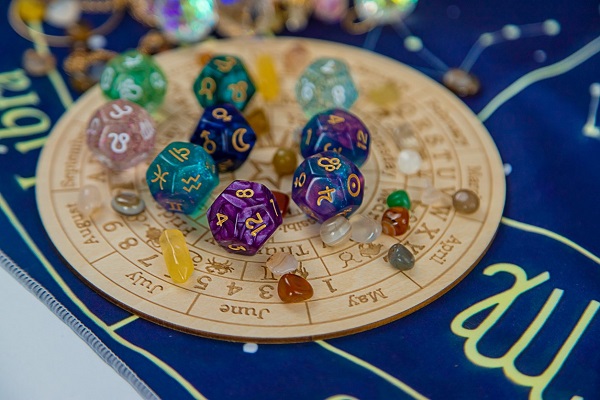imagine cu zaruri cu simboluri zodii pe o plansa cu lunile anului