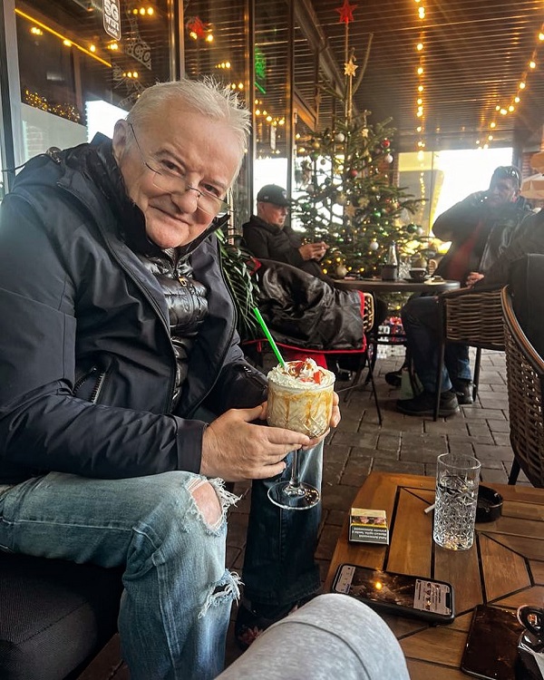 irinel columbeanu sta la o masa cu un cocktail in mana