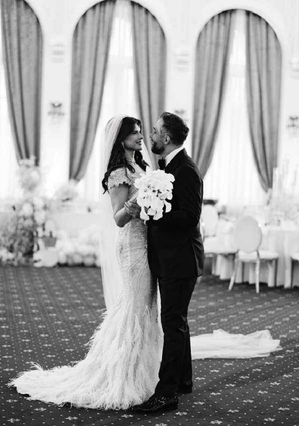 valeriu gheorghita si monica birladeanu imbracati in mire si mireasa danseaza tinand la piept flori