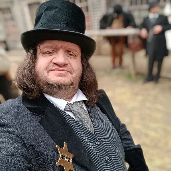 actorul valeriu pavel dan cu joben pe cap si emblema de serif in piept